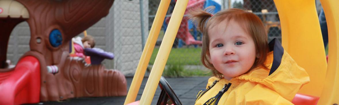 Baby Smiling in a Plastic Car